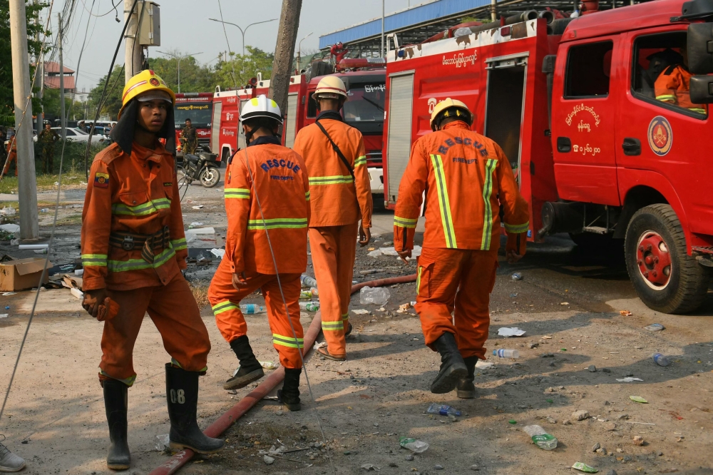 Members of the fire department walk near the site of the collapsed Sky Villa Condominium building in Mandalay on March 29, 2025. — AFP pic
