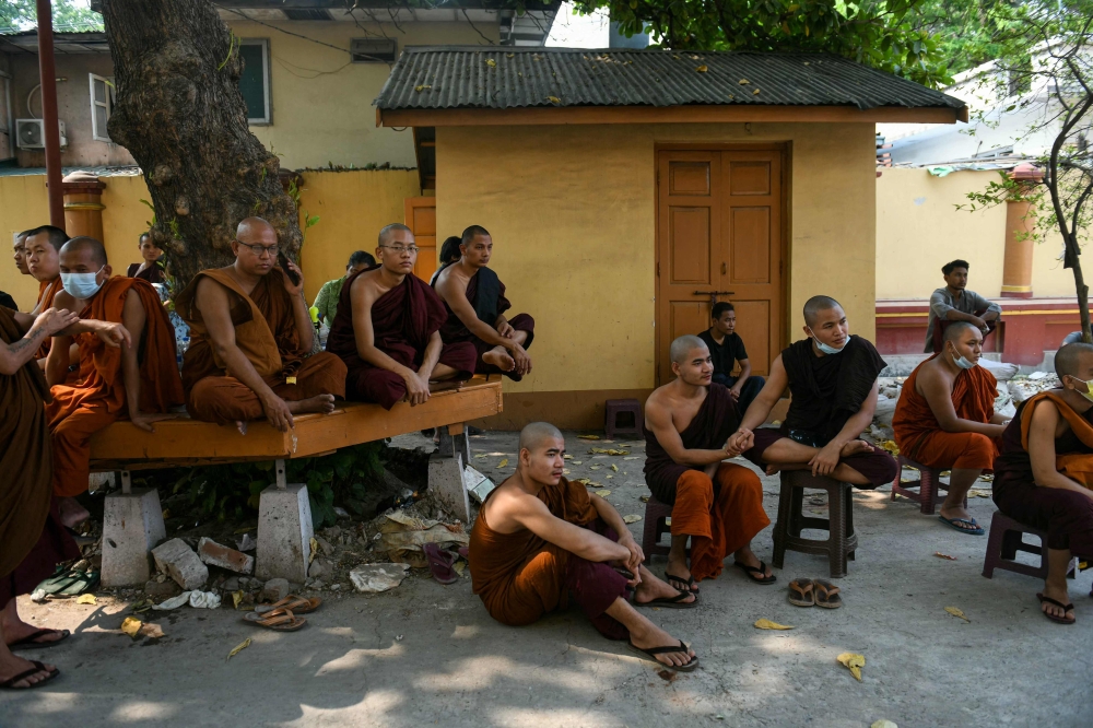Monks wait during search and rescue operations at a damaged temple in Mandalay on March 30, 2025, two days after an earthquake struck central Myanmar. — AFP pic