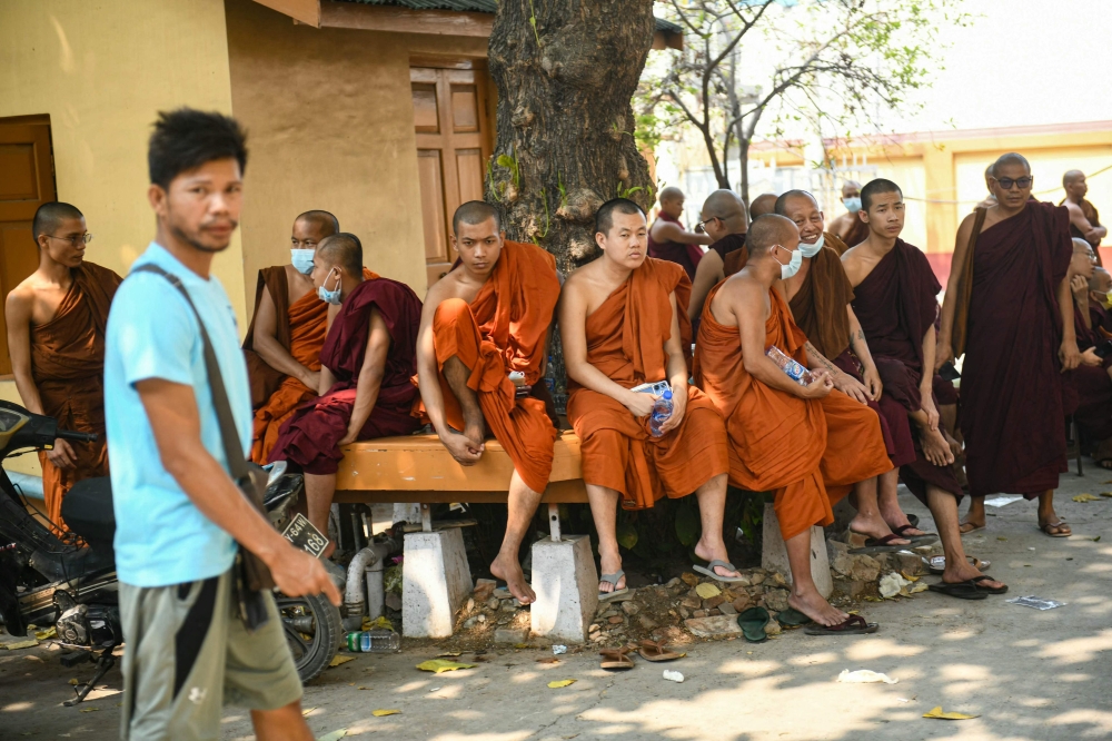 Monks wait during search and rescue operations at a damaged temple in Mandalay on March 30, 2025, two days after an earthquake struck central Myanmar. — AFP pic