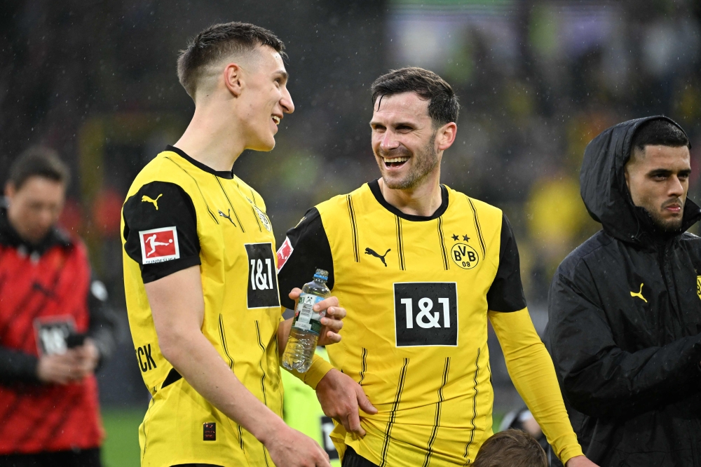Dortmund's German defender Nico Schlotterbeck (L) and midfielder Pascal Gross (C) celebrate after winning the German first division Bundesliga football match against Mainz.— AFP pic