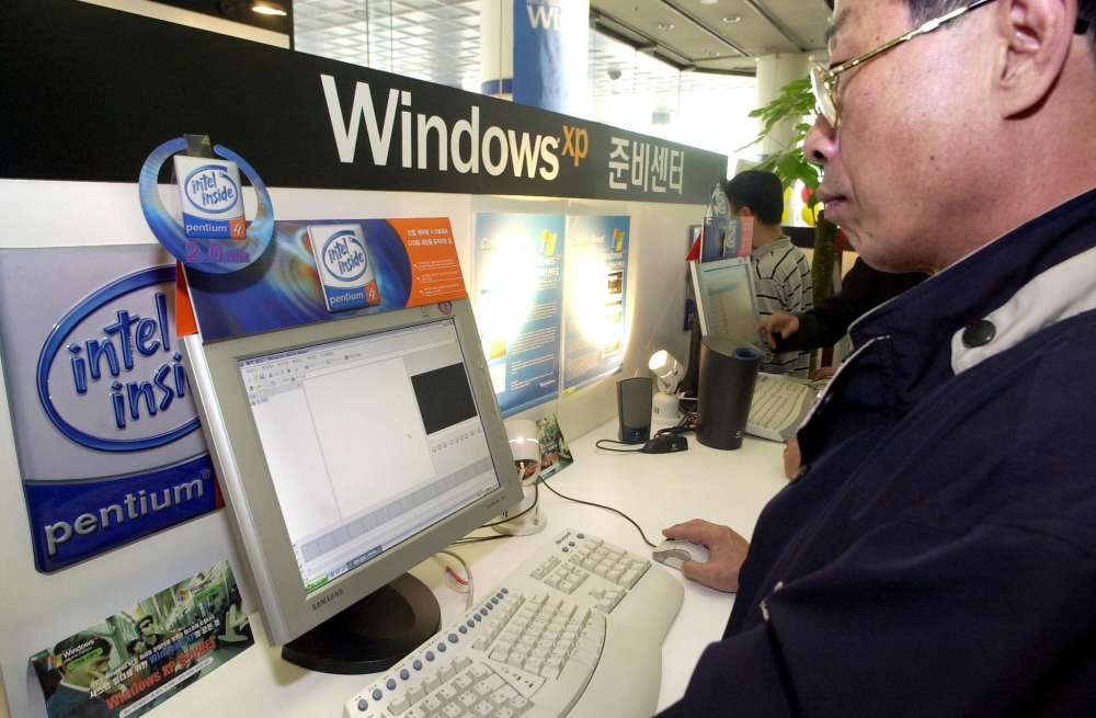 A South Korean man tests US software giant Microsoft latest operating system, Windows XP, at a showcase in Seoul's main computer shopping centre October 12, 2001. — AFP pic