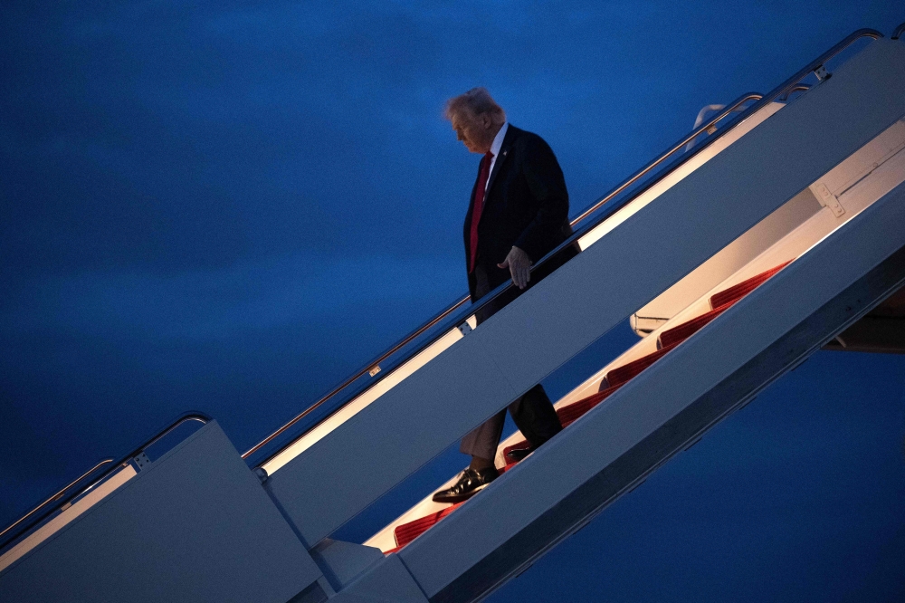 US President Donald Trump steps off Air Force One at Joint Base Andrews, Maryland, yesterday. — AFP pic