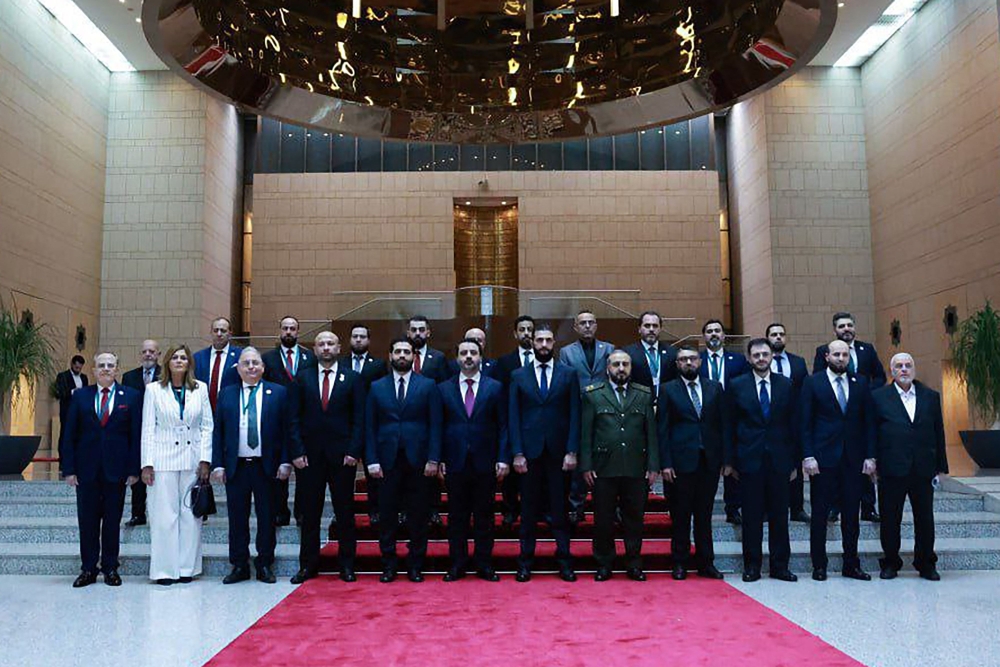 A handout picture released by the official Syrian Arab News Agency (Sana) on March 30, 2025, shows Syria's interim President Ahmed al-Sharaa (6th right) and Foreign Minister Asaad al-Shibani (6th left) posing for a picture with the new transitional government in Damascus. — Sana handout/AFP pic  