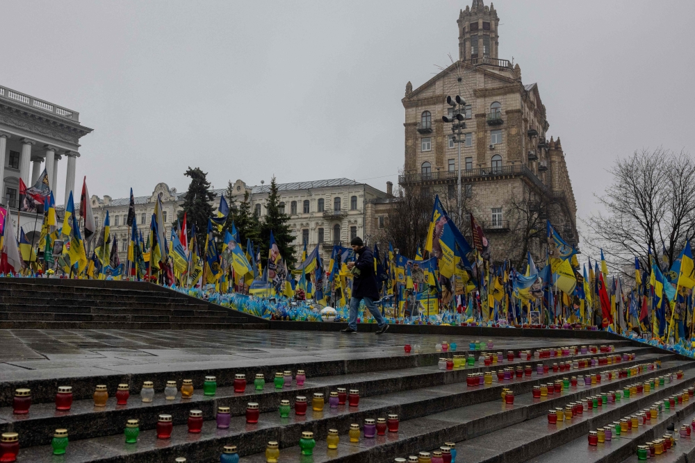 A man walks amongst displayed candles at the makeshift memorial for Ukrainian and foreign fighters at the Independence Square in Kyiv March 31 — AFP pic