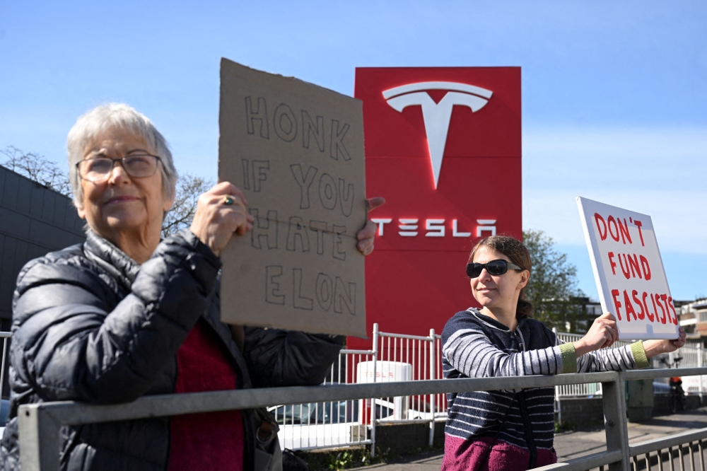 Protesters opposing billionaire Elon Musk gather outside a Tesla dealership in Acton, London, Britain, March 29. — Reuters pic