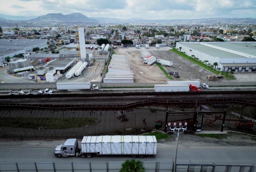 Trucks coming from Mexico enter the United States to an inspection station after crossing the border in Otay Mesa, California yesterday. US President Donald Trump is expected to announce sweeping new tariffs that could trigger a global trade war. — AFP pic