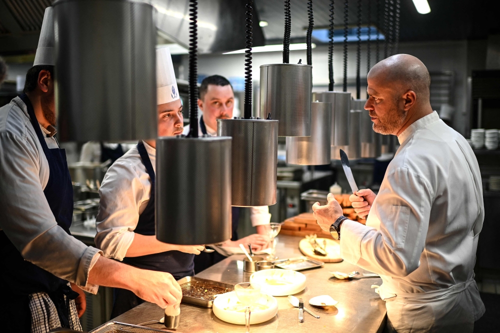 French chef Christopher Coutanceau (right) works with his team at his restaurant 'Christopher Coutanceau' in La Rochelle, western France on April 1, 2025. — AFP pic