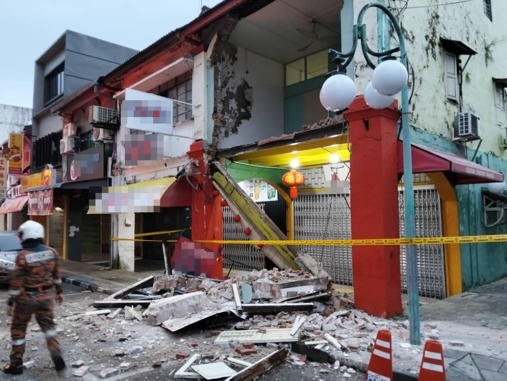 A shoplot unit’s wall along Jalan Padungan here collapsed early this morning. — The Borneo Post pic