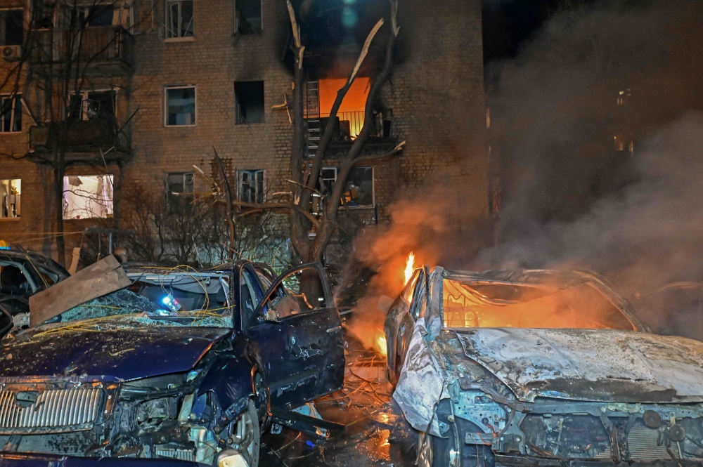 This photograph shows burning cars and fire in a damaged residential building at the site of a drone attack in Kharkiv late on April 3, 2025, amid the Russian invasion of Ukraine. — AFP pic