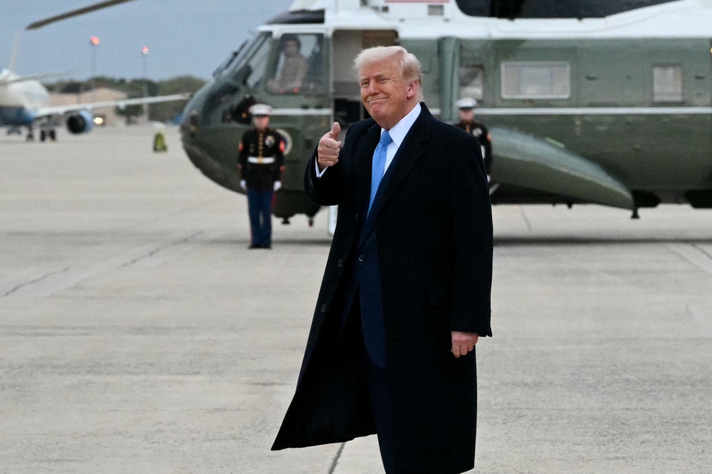 US President Donald Trump gives a thumbs up after stepping off Air Force One upon arrival at Joint Base Andrews in Maryland yesterday. — AFP pic