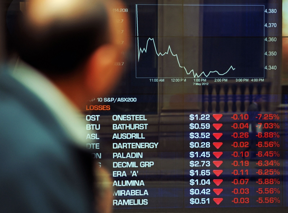 A city worker (L) walks past the Australian Stock Exchange in central Sydney on May 7, 2012. Australian blue-chip stocks sank six percent after trading opened today, as US President Donald Trump's sweeping tariffs continued to rattle global markets. — AFP pic