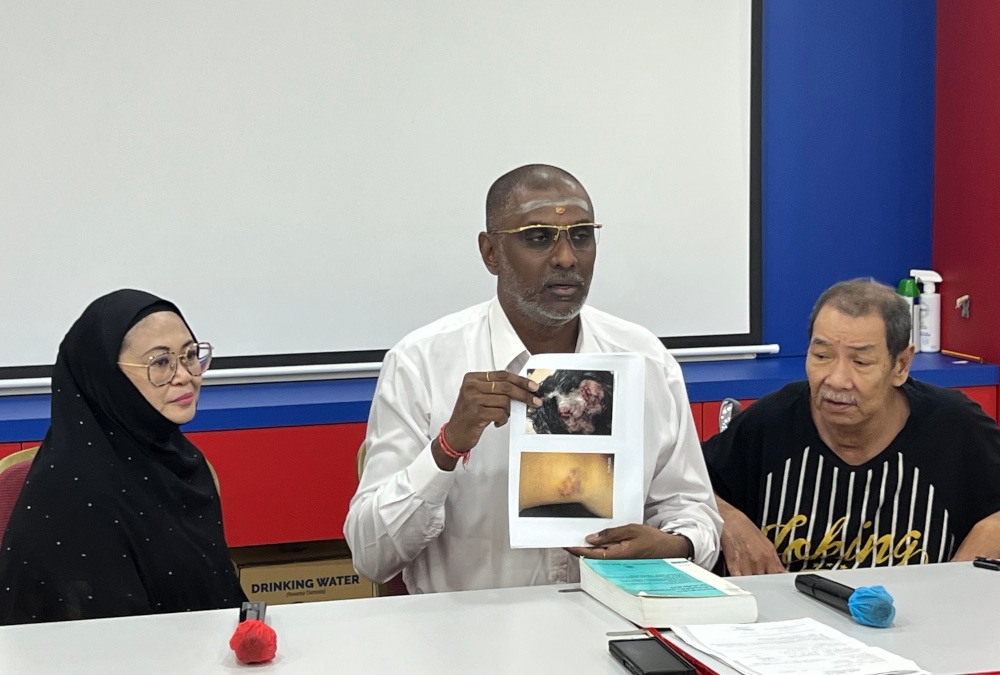 Jelutong MP and lawyer RSN Rayer with the victim, Rina Minda Sari, 47 and husband, Ahmad Hussin Hassan, 65. — Picture by Opalyn Mok