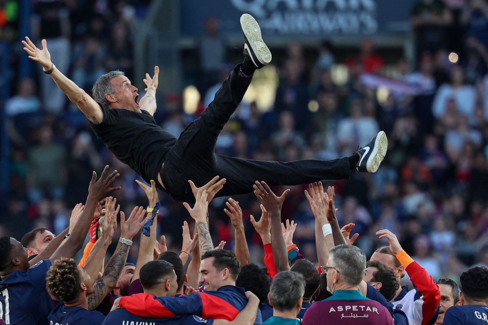 Paris-Saint Germain's players throw up in the air Paris Saint-Germain's Spanish headcoach Luis Enrique as they celebrate after winning the match and the French championship title after the French L1 football match between Paris Saint-Germain (PSG) and SCO Angers at The Parc des Princes Stadium in Paris April 5, 2025. Paris Saint-Germain clinched the Ligue 1 title on Saturday with a 1-0 win at home against Angers as they prepare for a Champions League quarter-final showdown with Aston Villa. — AFP pic