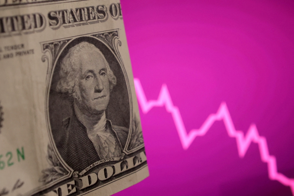 A USdollar banknote and decreasing stock graph are seen in this illustration taken, April 4, 2025.  — Reuters pic