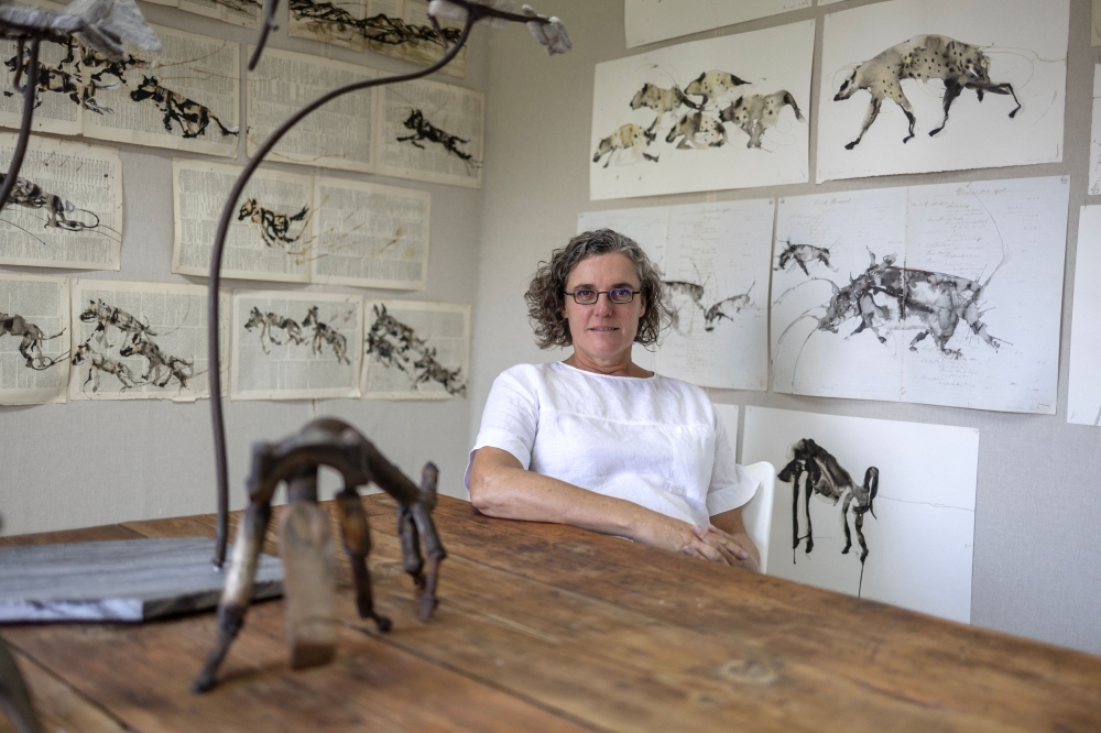 South African artist Hannelie Coetzee poses for a photograph at her studio in Johannesburg on March 26, 2025. The walls of her studio in the university district of downtown Johannesburg are covered in drawings in ink and rooibos tea of the sloped-back carnivore, her heroines of the bush. With cute ears but a frightening jaw, the animal is also represented in her sculptures fashioned from scavenged materials. — AFP pic