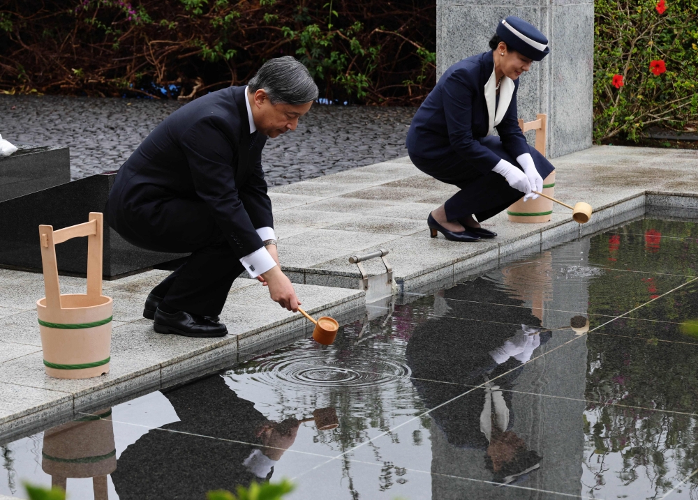 Japan's Emperor Naruhito and Empress Masako pour water on requiem hill as they visit the island of Iwo Jima, which is now officially called Ioto April 7, 2025. — Kim Kyung-hoon/Pool/AFP pic 