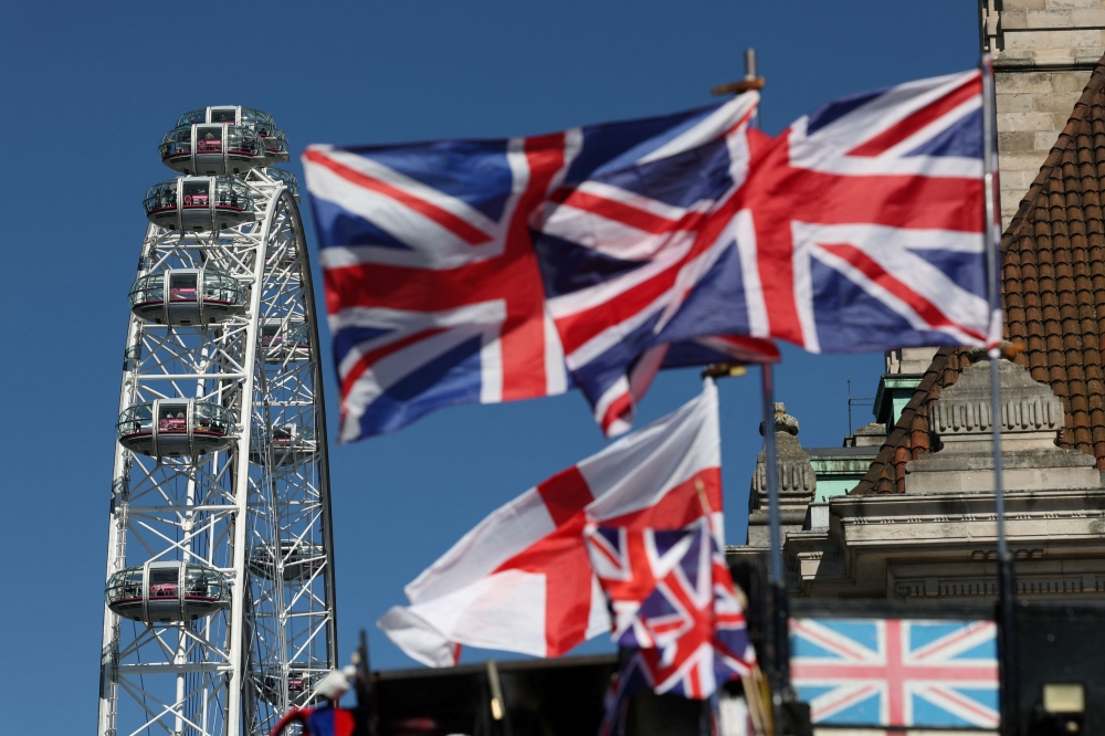 Union Jack flags flutter in the wind next to the London Eye, in London April 1, 2025. Britain said it could close hundreds of arms-length government agencies, as it looks to reform the state to cut costs and improve productivity in what it called ‘a new era of global instability’. — Reuters pic