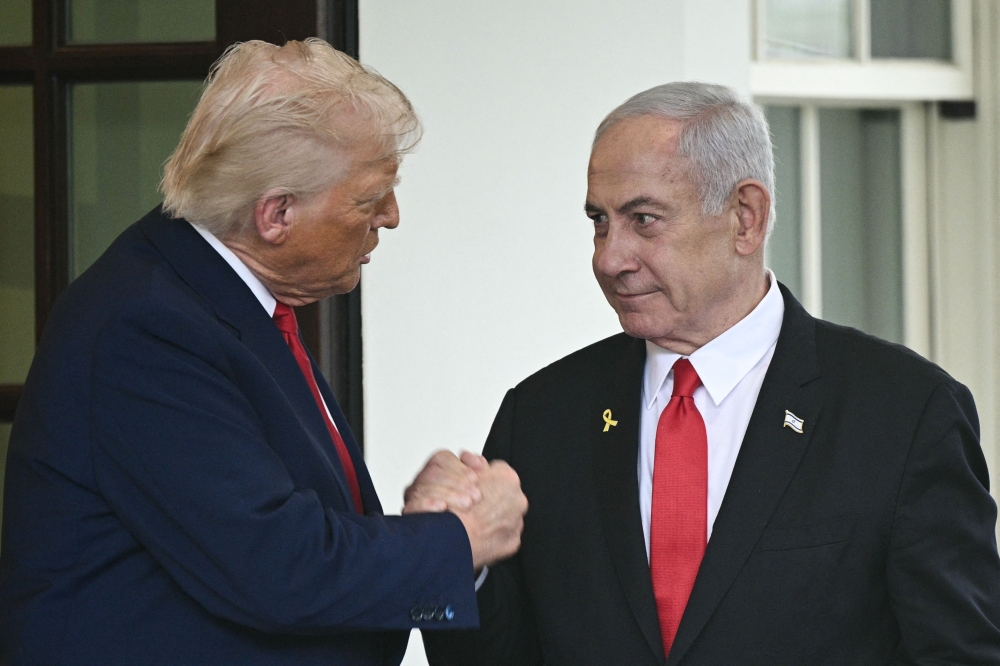 US President Donald Trump shakes hands with Israeli Prime Minister Benjamin Netanyahu as Netanyahu departs the White House in Washington, DC yesterday. — AFP pic