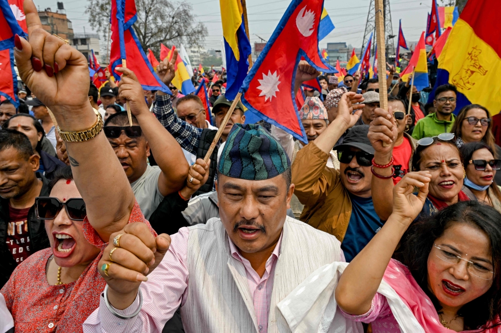 Supporters of Rastriya Prajatantra Party (RPP) wave Nepal's national flag and the party flag during a pro-monarchy protest to demand the restoration of monarchy and the status of a Hindu state in Kathmandu  April 8. — AFP pic