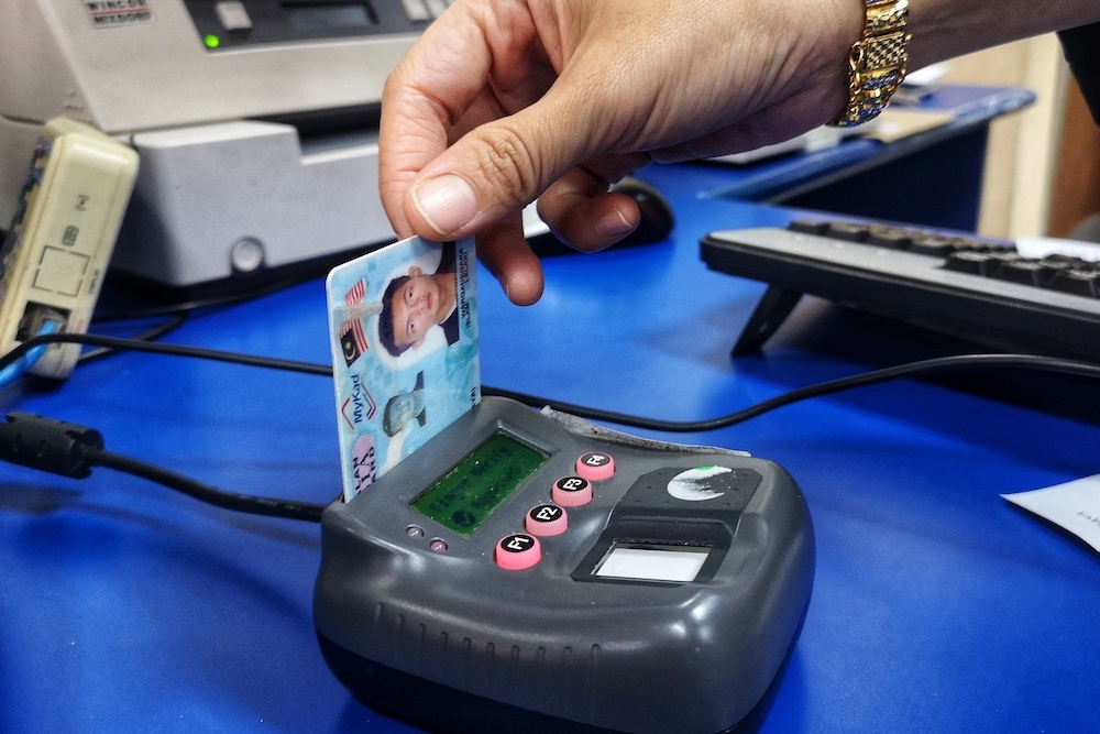 The NRD issued a MyKad to D this year and also corrected the error in her birth certificate. File photo of a MyKad card reader in use. — Picture by Shafwan Zaidon