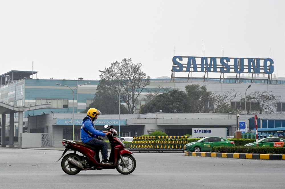 A man rides a motorbike through the entrance gate of Samsung’s electronic components factory in Bac Ninh province. Seeking low wages, South Korean tech giant Samsung Electronics has built factories in Vietnam for years, with nearly half its high-end mobile phones now put together in the South-east Asian country. — AFP pic
