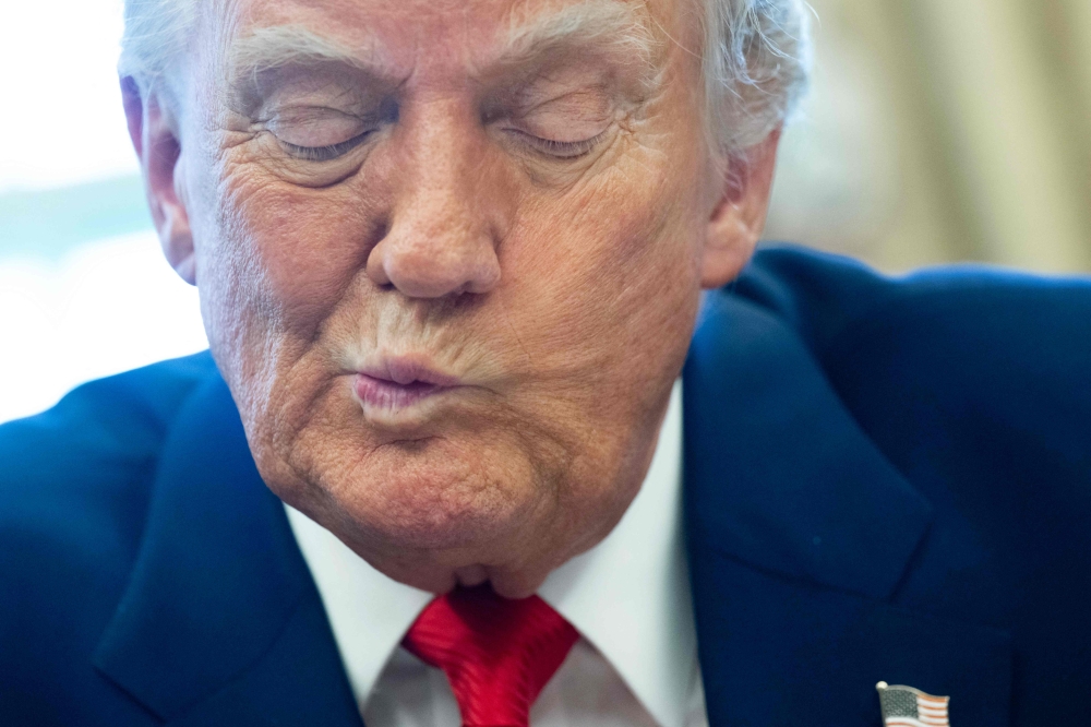 US President Donald Trump speaks after signing an executive order in the Oval Office of the White House yesterday in Washington, DC. — AFP pic