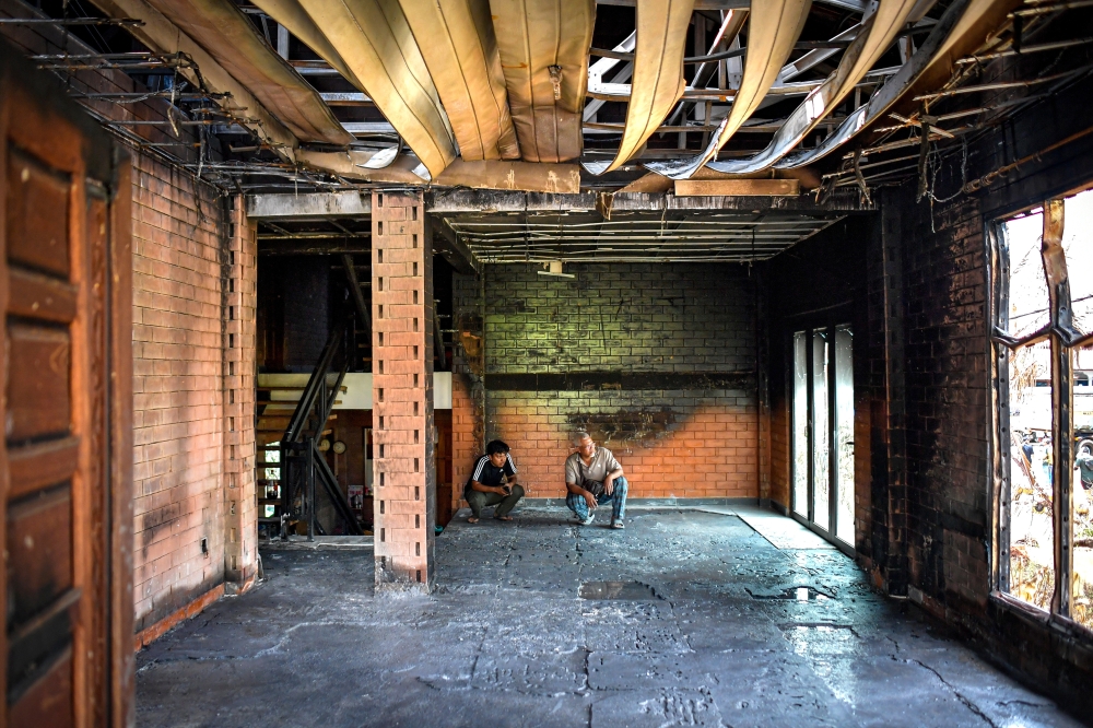 Ahmad Baharudin Hamid, a resident of Kampung Kuala Sungai Baru, inspecting his home with his son. — Bernama pic