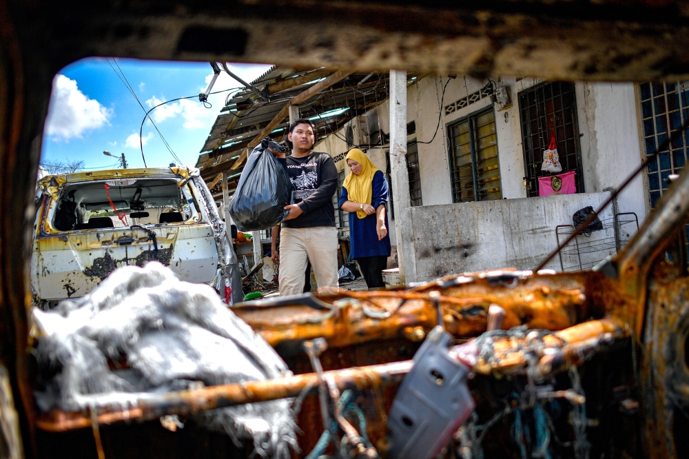 Volunteers and residents working together to clean up the area. — Bernama pic