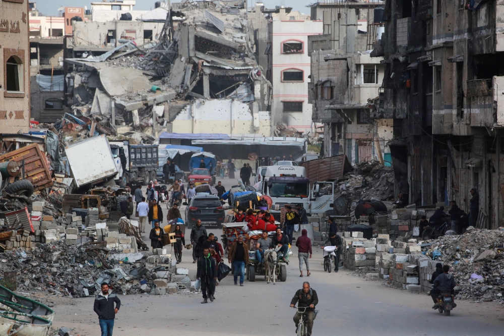 Palestinians ferry their belongings as they arrive in Gaza City to flee neighbourhoods to the east of the city following Israeli evacuation orders on April 11. — AFP pic