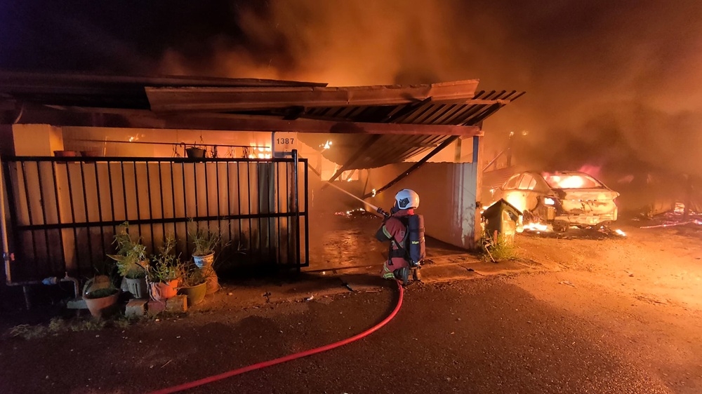 Handout photo shows a firefighter extinguishing flames at one of the affected units at Lorong B5 in RPR Sebiew. — Picture courtesy of the Fire and Rescue Department 