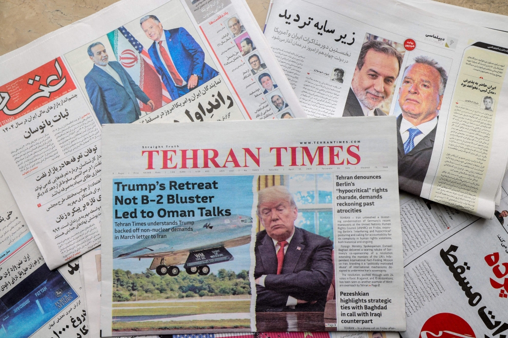 A picture shows newspaper frontpage headlines at a kiosk in Tehran April 12, 2025, featuring the Iran-US talks on the Iranian nuclear programme set to begin in Oman on the same day. — AFP pic