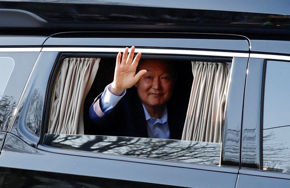Ousted former South Korean President Yoon Suk Yeol gestures from a vehicle, as he returns to his former residence in an apartment complex in Seoul, South Korea, April 11, 2025. — Reuters pic 