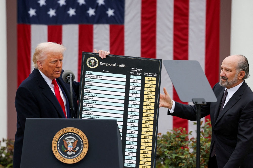 US President Donald Trump holds a chart next to US Secretary of Commerce Howard Lutnick as Trump delivers remarks on tariffs in the Rose Garden at the White House in Washington DC, April 2, 2025. — Reuters pic 