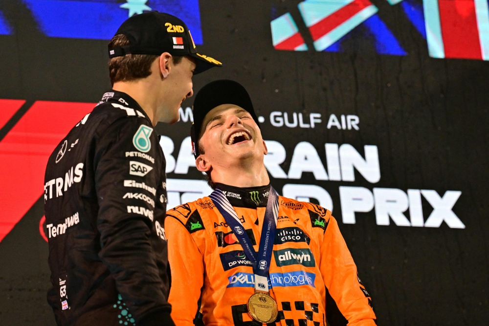 McLaren’s Australian driver Oscar Piastri and Mercedes’ British driver George Russell share a light time on the podium after the Bahrain Formula One Grand Prix at the Bahrain International Circuit in Sakhir on April 13, 2025. — AFP pic 