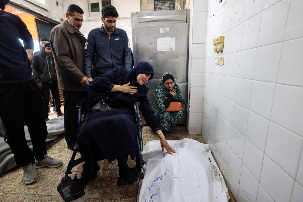 A woman sitting in a wheelchair mourns over the body of a relative killed in an Israeli strike, at the al-Aqsa Martyrs hospital in Deir el-Balah in the central Gaza Strip on April 13, 2025. — AFP pic 