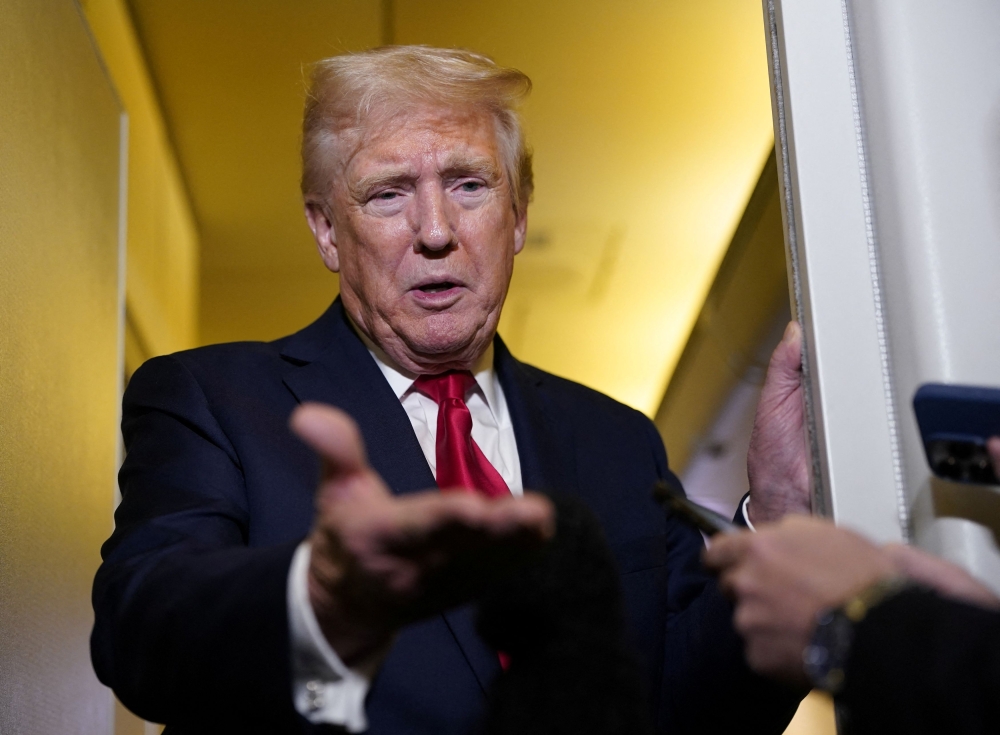 US President Donald Trump speaks to members of the media onboard Air Force One, on a flight to Joint Base Andrews in Maryland, April 13, 2025. — Reuters pic 