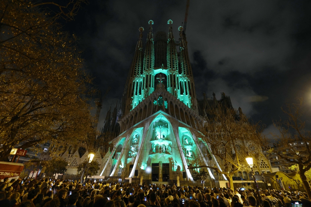 People watch a light show projected on the facade of Spanish architect Antoni Gaudi’s Sagrada Familia Basilica, marking the start of the Holy Week, in Barcelona on April 14, 2025. The Catholic Church has put Antoni Gaudi, the designer of Barcelona's Sagrada Familia basilica nicknamed ‘God’s architect’, on the path to sainthood, the Vatican said today. — AFP pic