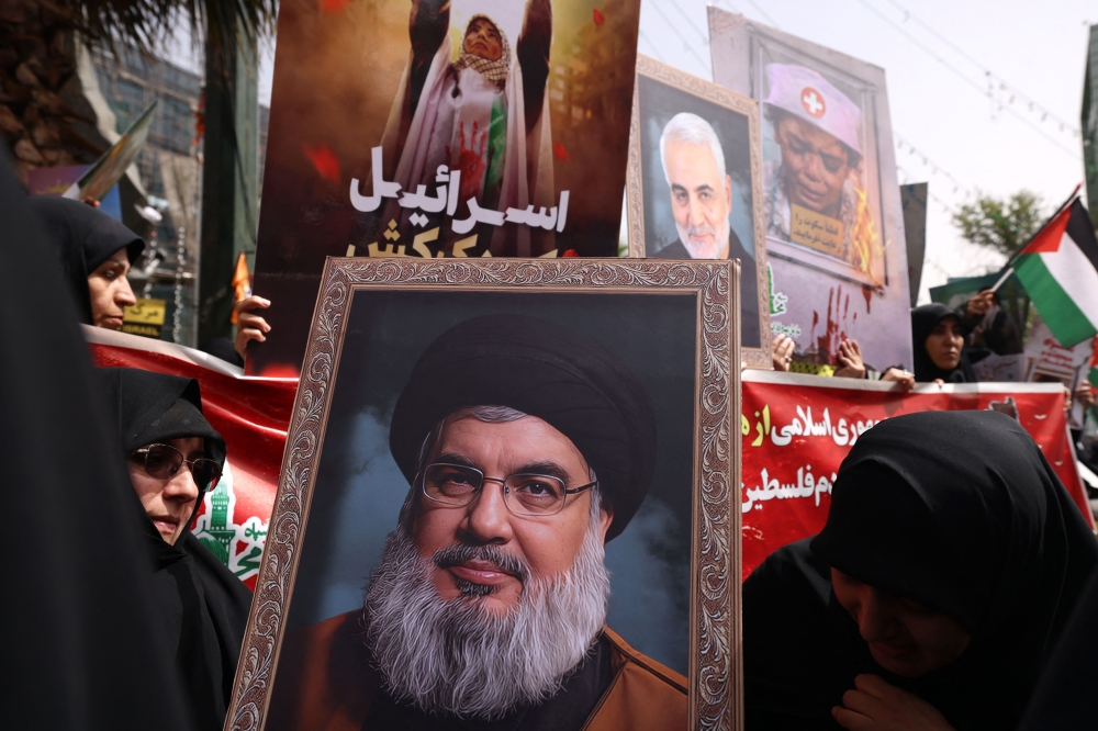 Iranian protesters hold portraits of slain Lebanese Hezbollah leader Hassan Nasrallah (C) and General Qasem Soleimani (top), the commander of Iran's Revolutionary Guards foreign operations who was killed in a 2020 US strike in Iraq. — AFP pic