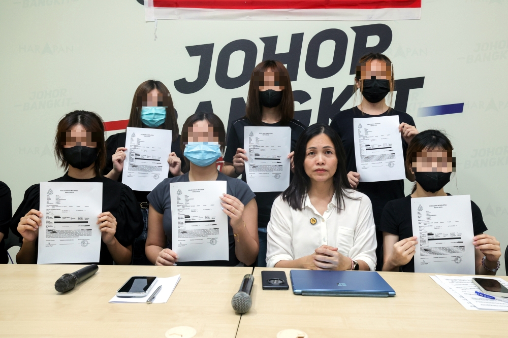 Deputy Minister of Communications and Kulai Member of Parliament, Teo Nie Ching (front row, 2nd right) with six of the 38 victims of the deepfake photo case involving 18-year-old private secondary school students, showing a copy of the police report that was made, at the Kulai Member of Parliament's Office April 12, 2025. — Bernama pic
