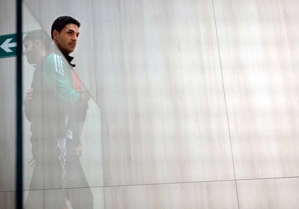Arsenal goalkeeper David Raya and Arsenal coach Mikel Arteta pass each other after giving a press conference at Santiago Bernabeu Stadium in Madrid on April 15, 2025, on the eve of the Uefa Champions League quarter final second leg football match between Real Madrid CF and Arsenal. — AFP pic 