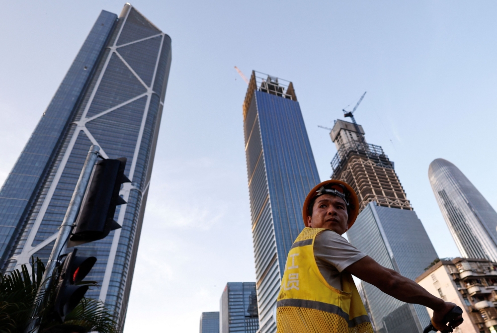 A construction worker rides a bike on a street in Guangzhou, Guangdong province, China April 15, 2025. hina’s first-quarter economic growth beat expectations, underpinned by solid consumption and industrial output even as policymakers brace for the impact of US tariffs that analysts say pose the biggest risk to the Asian powerhouse in decades. — Reuters pic