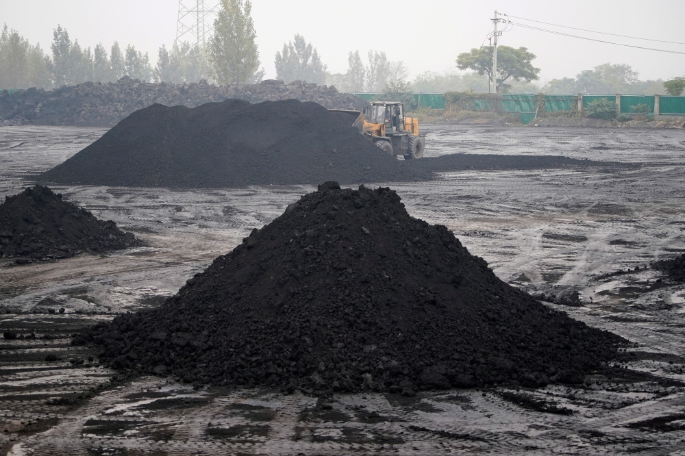 An excavator sift through dunes of low-grade coal near a coal mine in Pingdingshan, Henan province November 5, 2021. Australian coal mines may have vastly underestimated historical methane emissions, according to analysis of the potent greenhouse gas published today. — Reuters pic