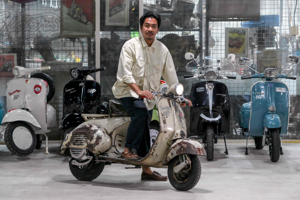 Heret Frasthio, CEO of Elders, posing on a Vespa that has been converted to an electric scooter at the Elders workshop in Jakarta. — AFP pic