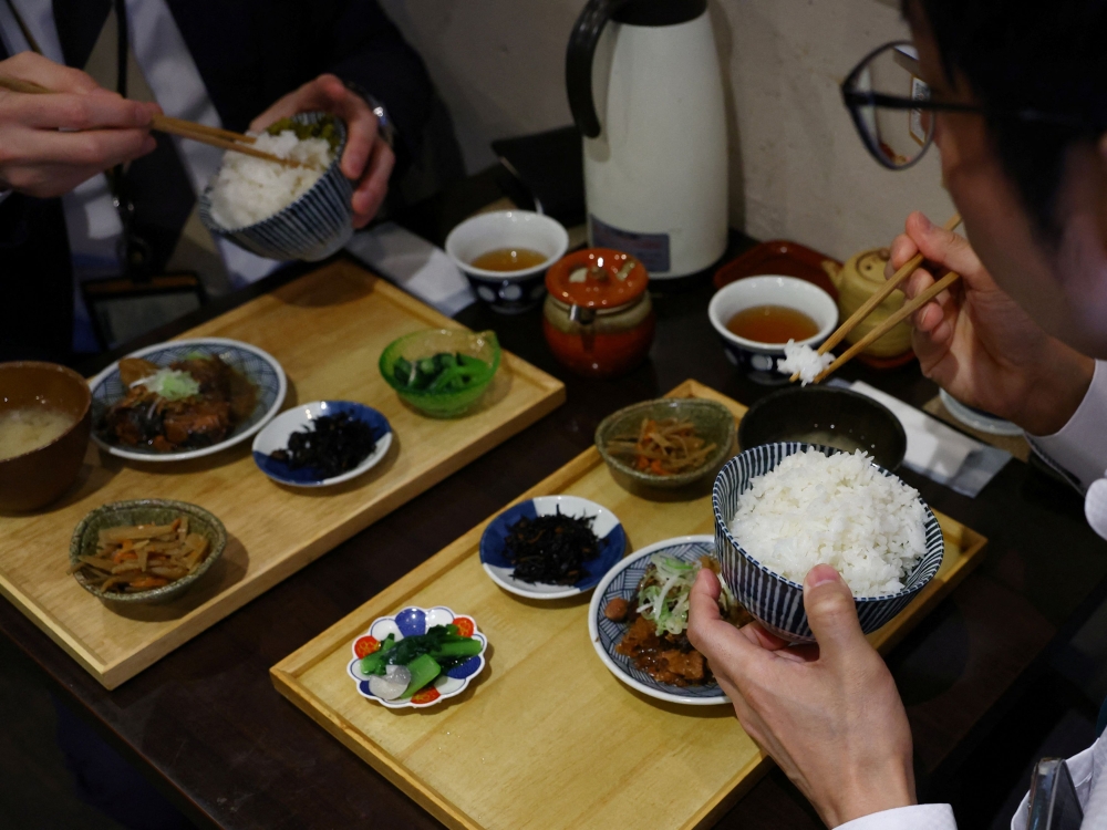 Customers eat cooked California-grown Calrose rice and side dishes at Shokudou Arata, a restaurant in Tokyo April 14, 2025. — Reuters pic 