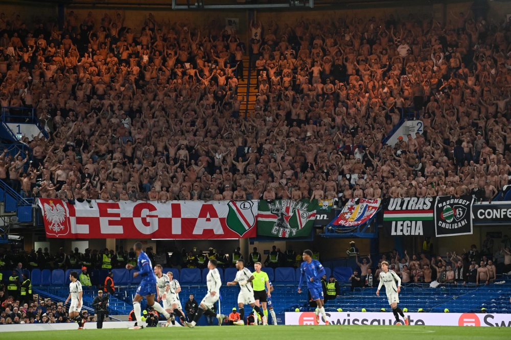 Legia fans with their shirts off during the UEFA Europa Conference League quarter-final, second leg football match between Chelsea and Legia Warsaw at Stamford Bridge in London on April 17, 2025. — AFP pic