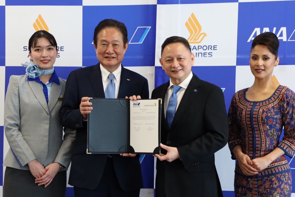 ANA chief executive Shinichi Inoue (left) and SIA chief executive Goh Choon Phong after signing the joint venture agreement. — Picture from Facebook/All Nippon Airways