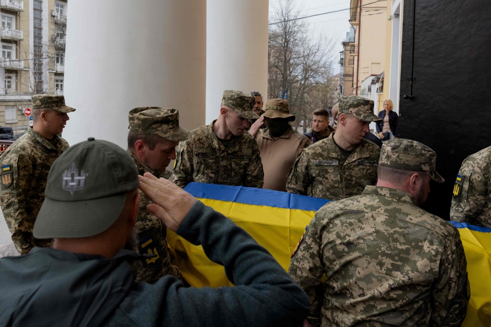 Ukrainian soldiers carry the coffin of 20-year-old Tomas Valentelis, callsign 