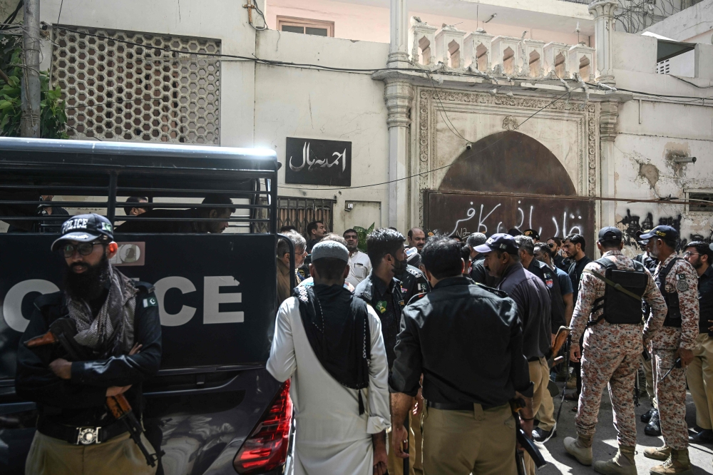 Police personnel stand guard outside a place of worship of the Ahmadiyya community in Karachi on April 18, 2025. — AFP pic