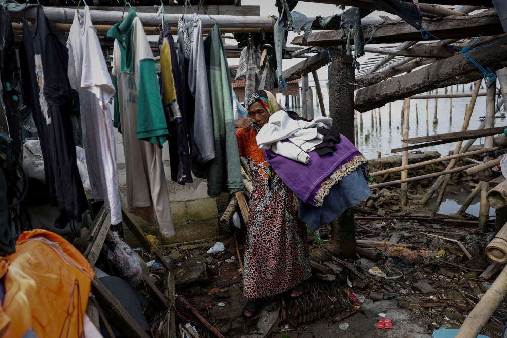 A woman carries laundry at her home in Rejosari Senik, Demak regency, Central Java Province, Indonesia, February 20, 2025. — Reuters pic