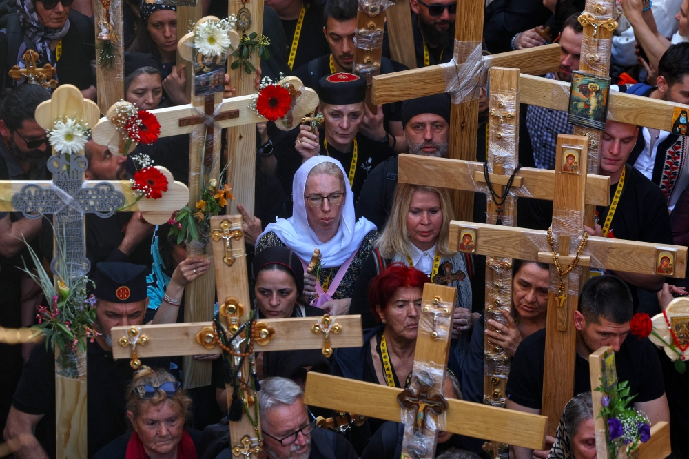 Chrisians carrying crosses walk through Jerusalem's Old City on their way to the Holy Sepulcre church during the Orthodox Good Friday procession on April 18, 2025. — AFP pic